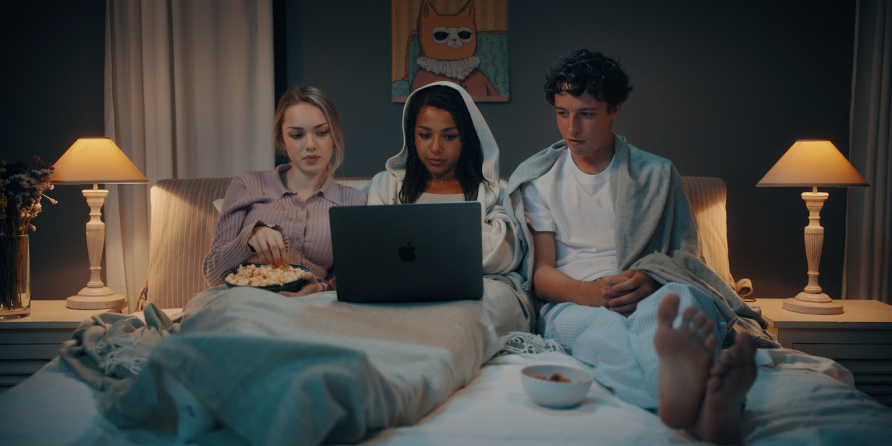 Noemi (Paula Unlabeled), Eli (Luna Baptiste) und Leo (Emil Baikousis) schauen Film. Frame aus Prime Video Serie 'Die neue Generation Krass Klassenfahrt'.