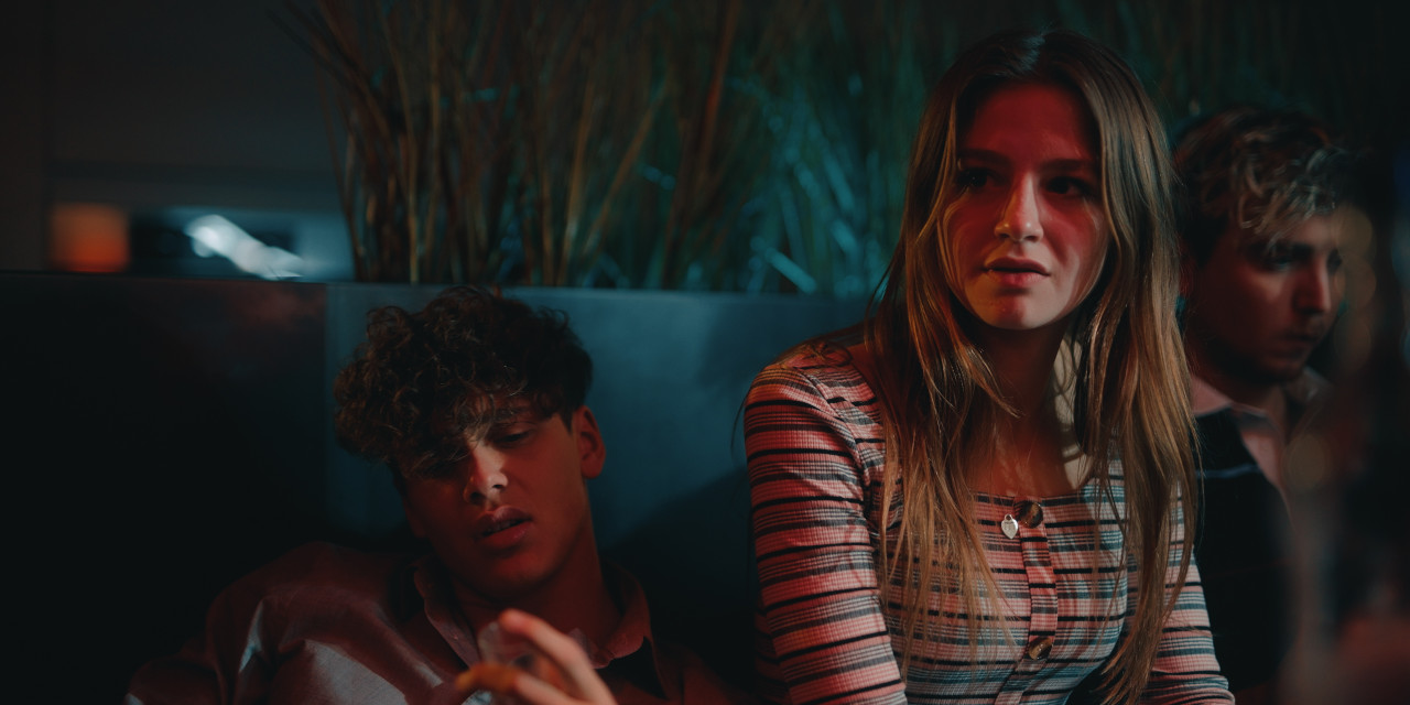 Emma (Flora Li Thiemann) und Noah (Bene Schulz) sitzen am Tisch. Frame aus Prime Video Serie "TOXISCH".