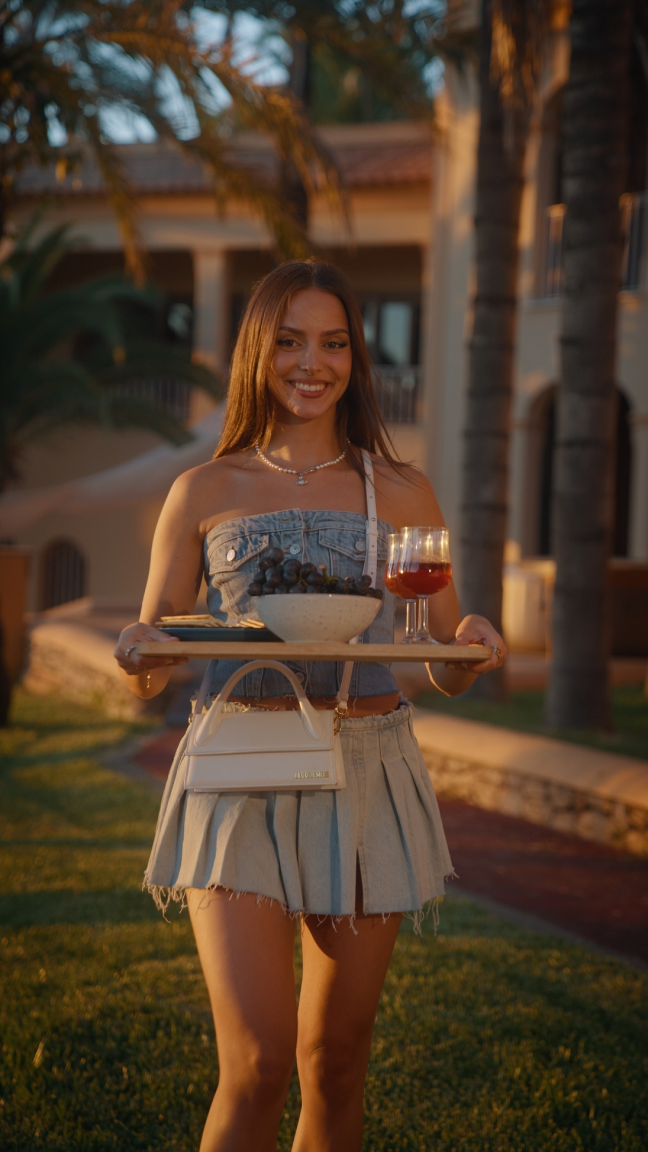 Frame aus Social Clips "House of Fashion". andrea_subotic mit Tablett bei Sonnenuntergang.