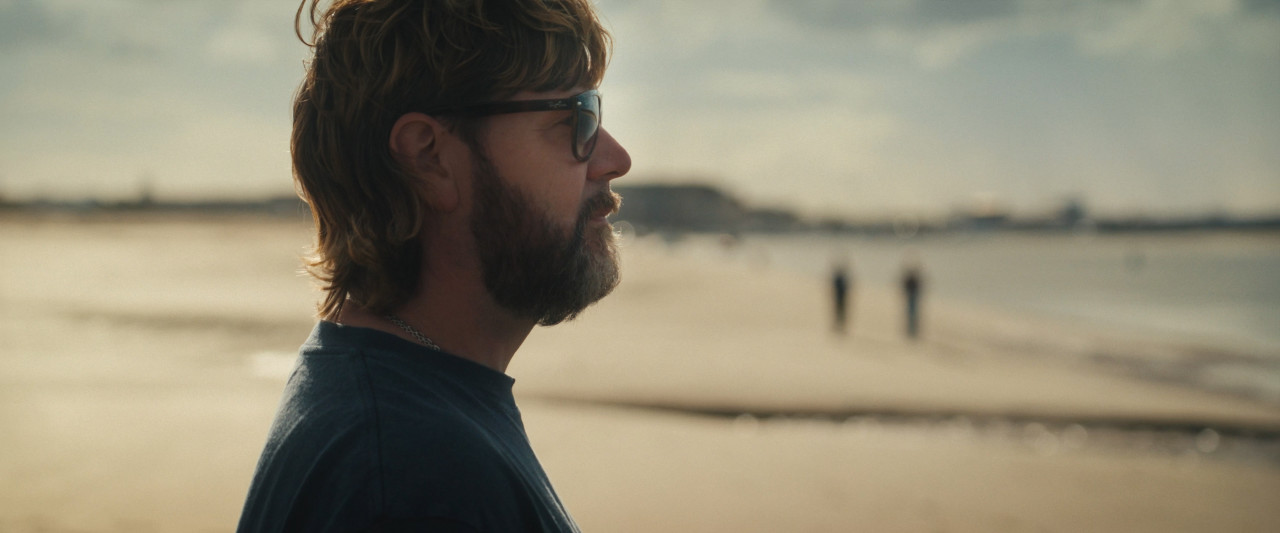 Nahaufnahme von Rea Garvey am Strand. Frame aus Doku "You'll be Grand".