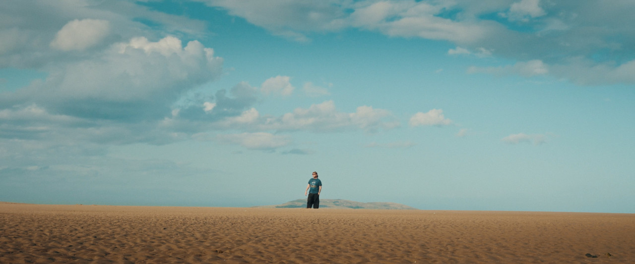 Supertotale von Rea Garvey am Strand. Frame aus Doku "You'll be Grand".