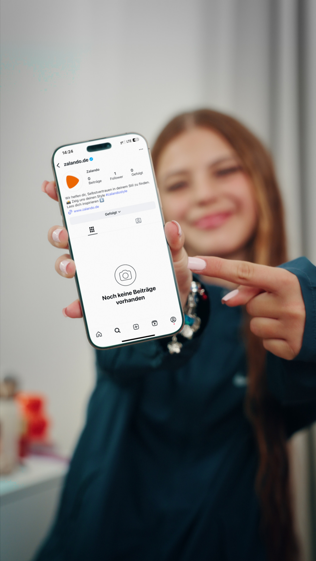 Zah1de zeigt auf iPhone mit Zalando.de Instagram Account. Frame aus Social Spot 'Zalando.de x Zah1de'.